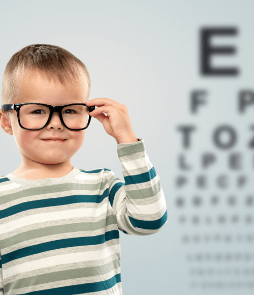 chlopiec w okularach-w gabinecie u okulisty-w tle-tablica do sprawdzania wzroku
